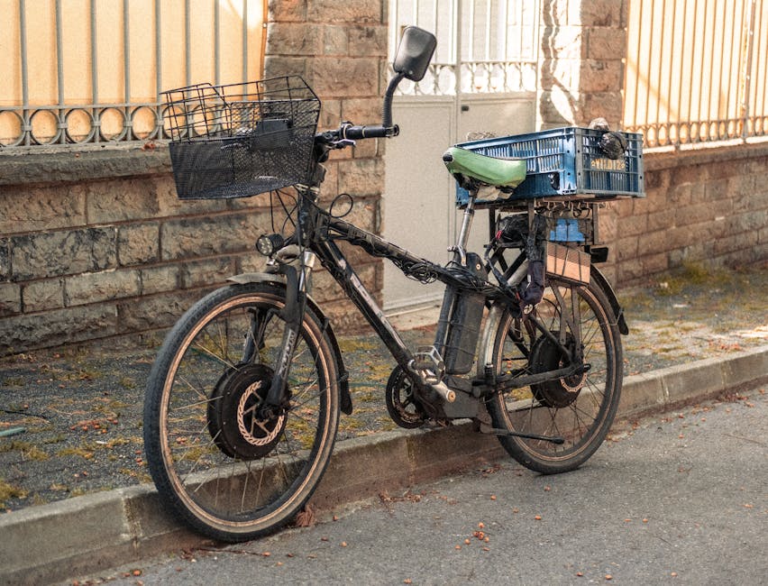 Old bicycle with baskets parked on an urban sidewalk, ideal for city transport visuals.
