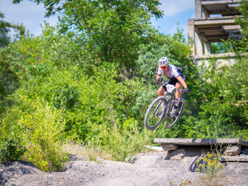 Dynamic shot of a biker performing a jump in rural Tulcea, highlighting speed and adventure.