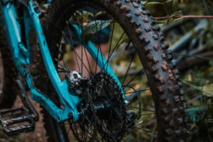 A detailed view of a muddy mountain bike showcasing rear gears and wet conditions.